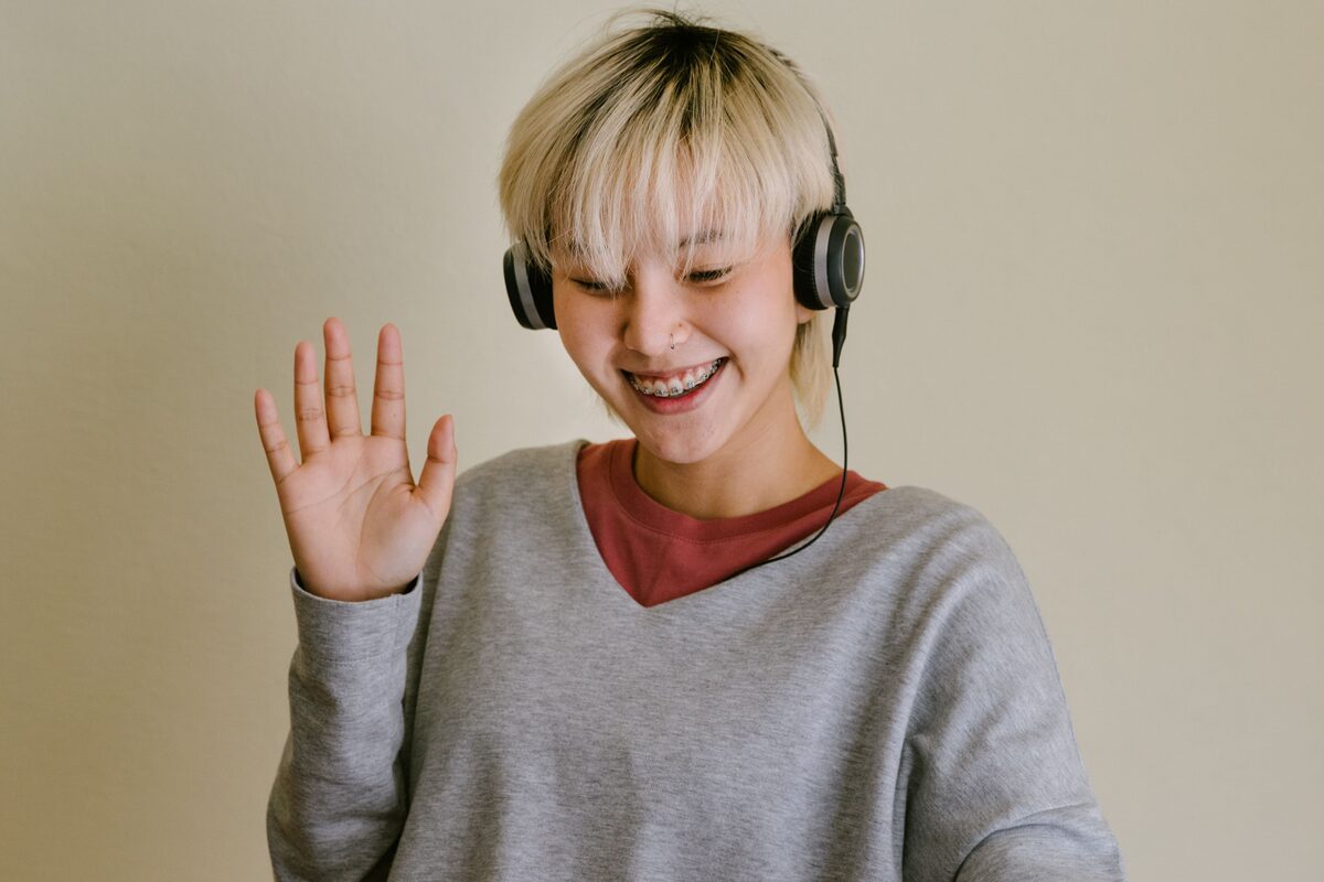 A woman at home waving during a video call