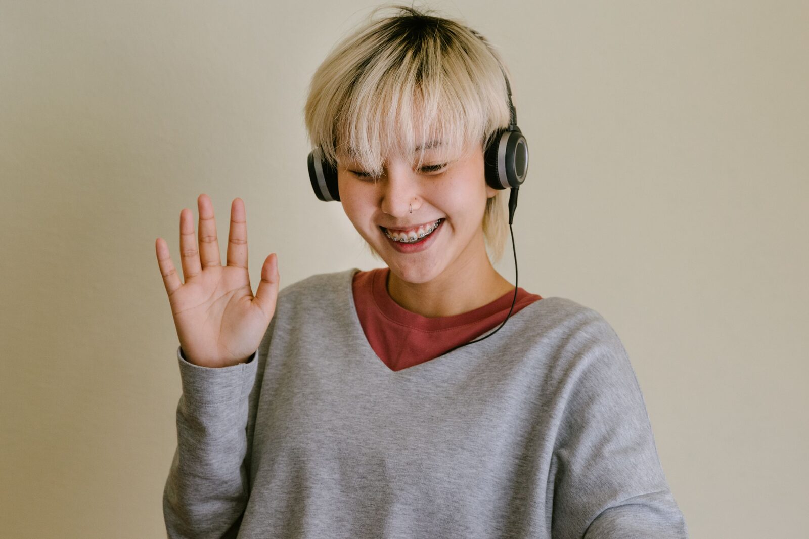 A woman at home waving during a video call